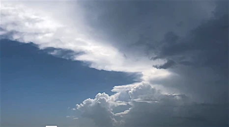 Dramatic cloudscape with white cumulus clouds against a blue sky, creating a serene and airy atmosphere.