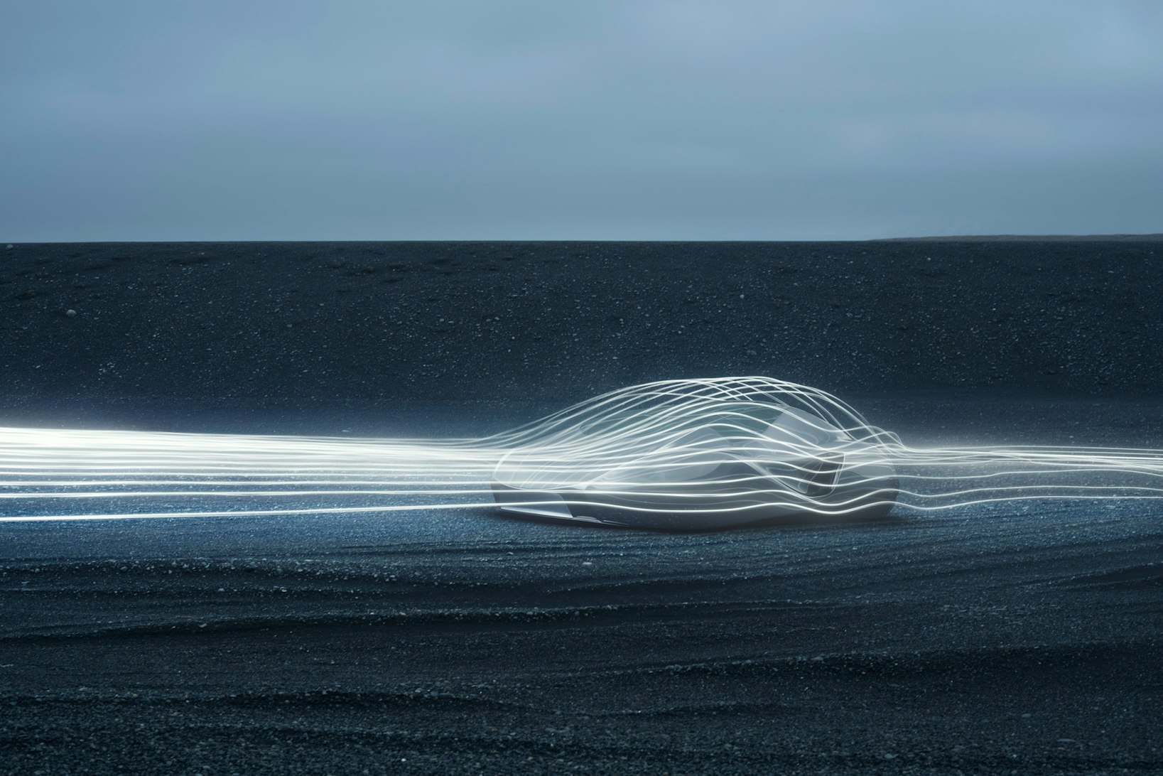Abstract light painting on black sand beach, featuring a bright, elongated shape created by light trails and a moody sky.