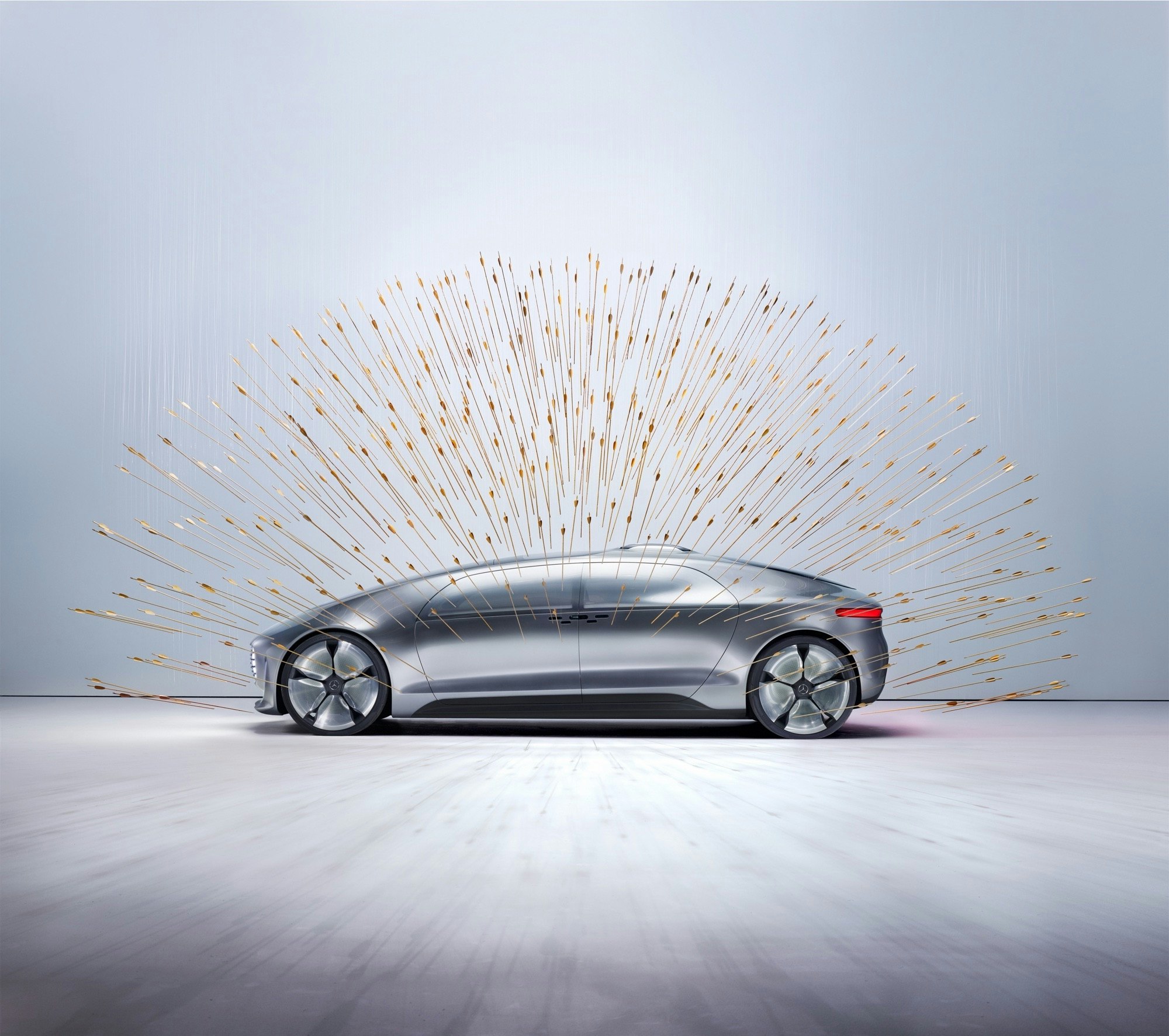 Futuristic silver car in a neutral setting, surrounded by a burst of radiating gold light for a modern, conceptual automotive image.