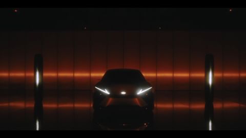 Sleek silhouette of a dark car with illuminated headlights in a dimly lit, modern space, highlighted by vertical light pillars.
