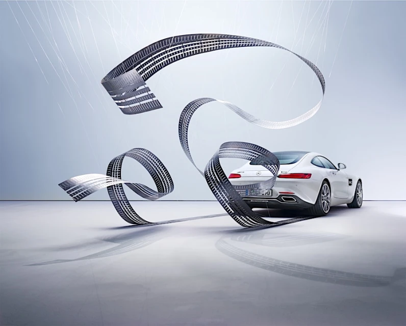 White Mercedes-AMG GT automobile with tire track ribbon, studio shot. Luxury vehicle, automotive advertising, and product showcase.