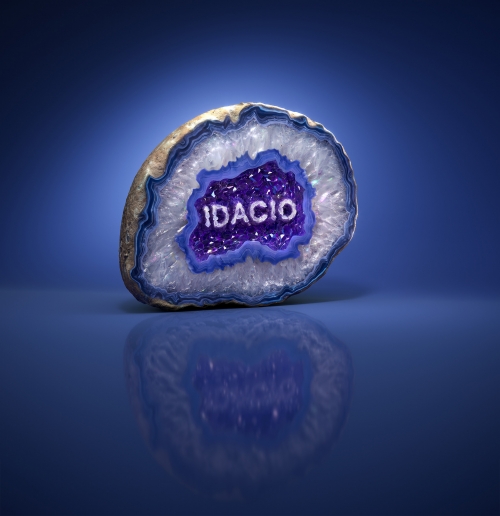 Geode slice featuring layers of white, blue, and purple crystals, with the word "IDACIO" displayed in the center, against a blue gradient.