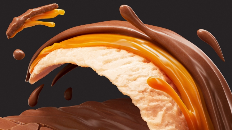Close-up of an ice cream bar with chocolate and caramel drizzle on a dark background, showing the creamy texture.