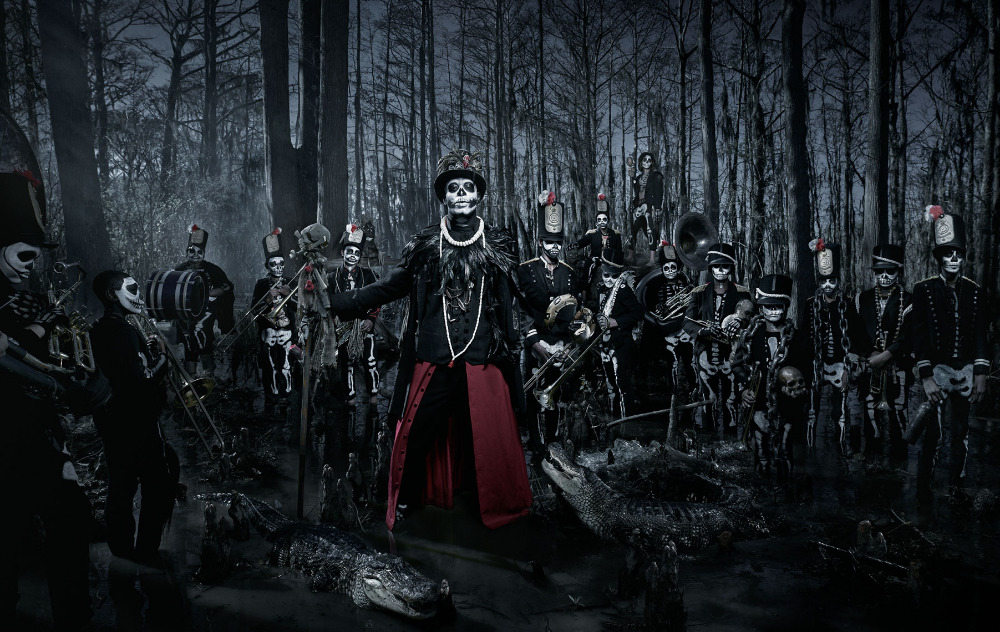 Spooky skeleton brass band with skeleton face paint performs in swampy forest among alligators in a dark, moody photograph.