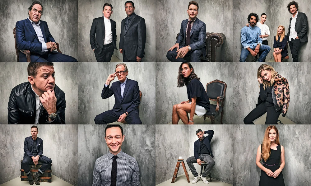 Group studio portrait of celebrity actors and actresses, some seated, in fashionable clothing against a textured gray backdrop.