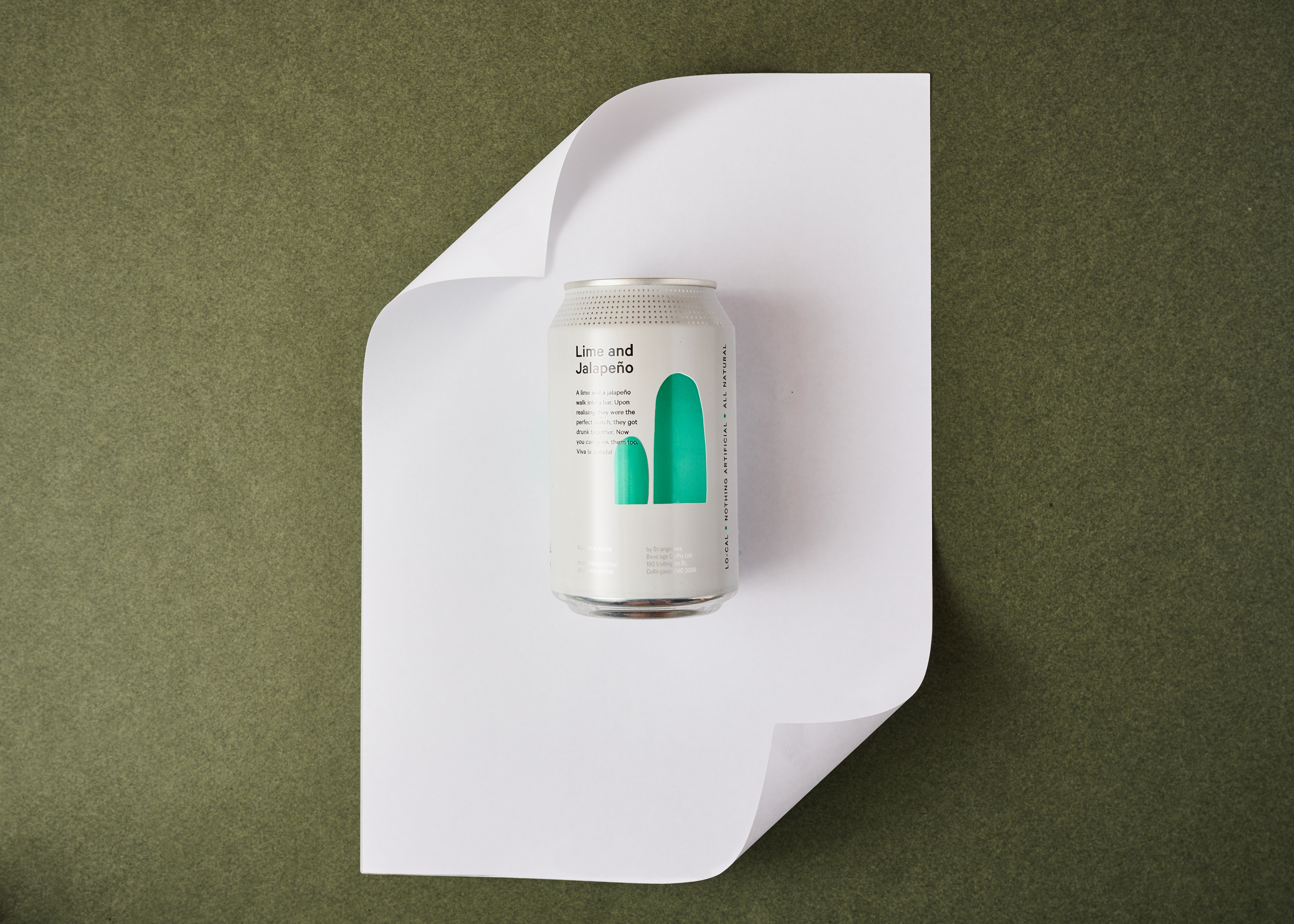 Craft soda can of Lime and Jalapeno flavor on a white surface, overhead shot, with an olive green background in studio lighting.