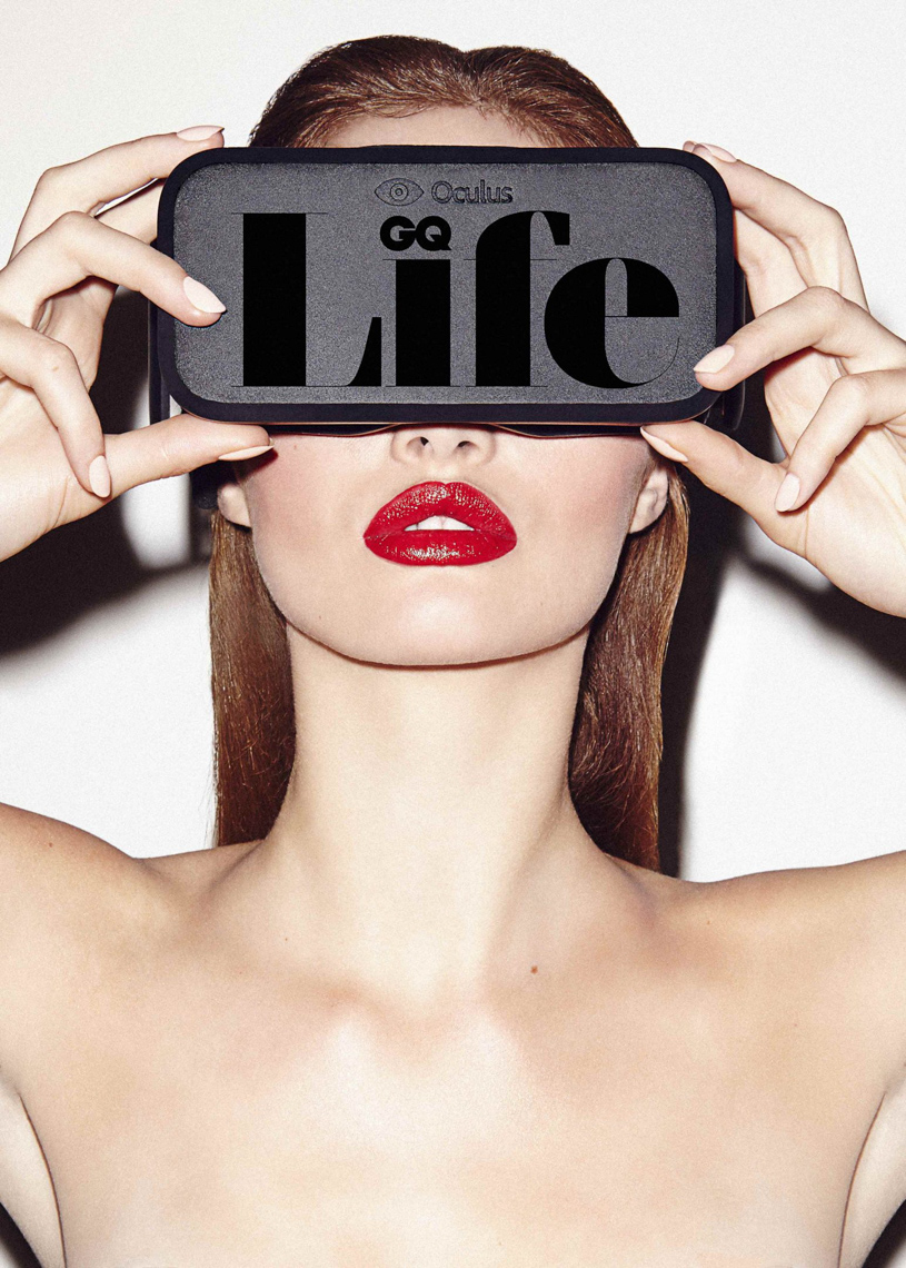 Headshot of a model wearing a virtual reality headset with red lipstick, against a white background in a brightly lit photo studio.