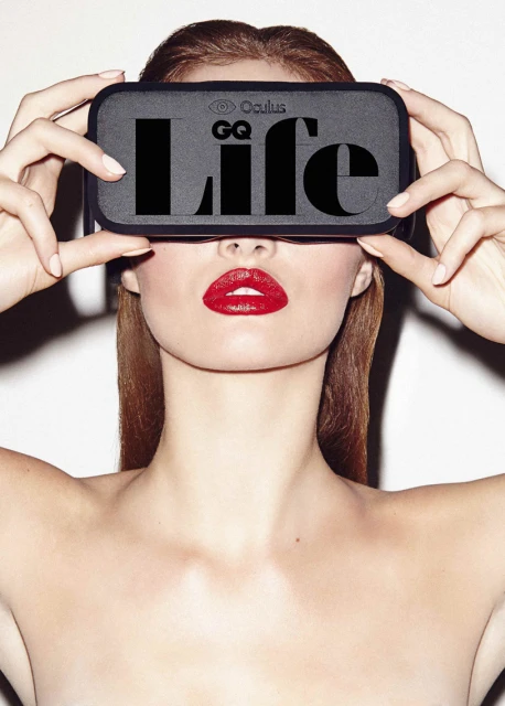 Headshot of a model wearing a virtual reality headset with red lipstick, against a white background in a brightly lit photo studio.