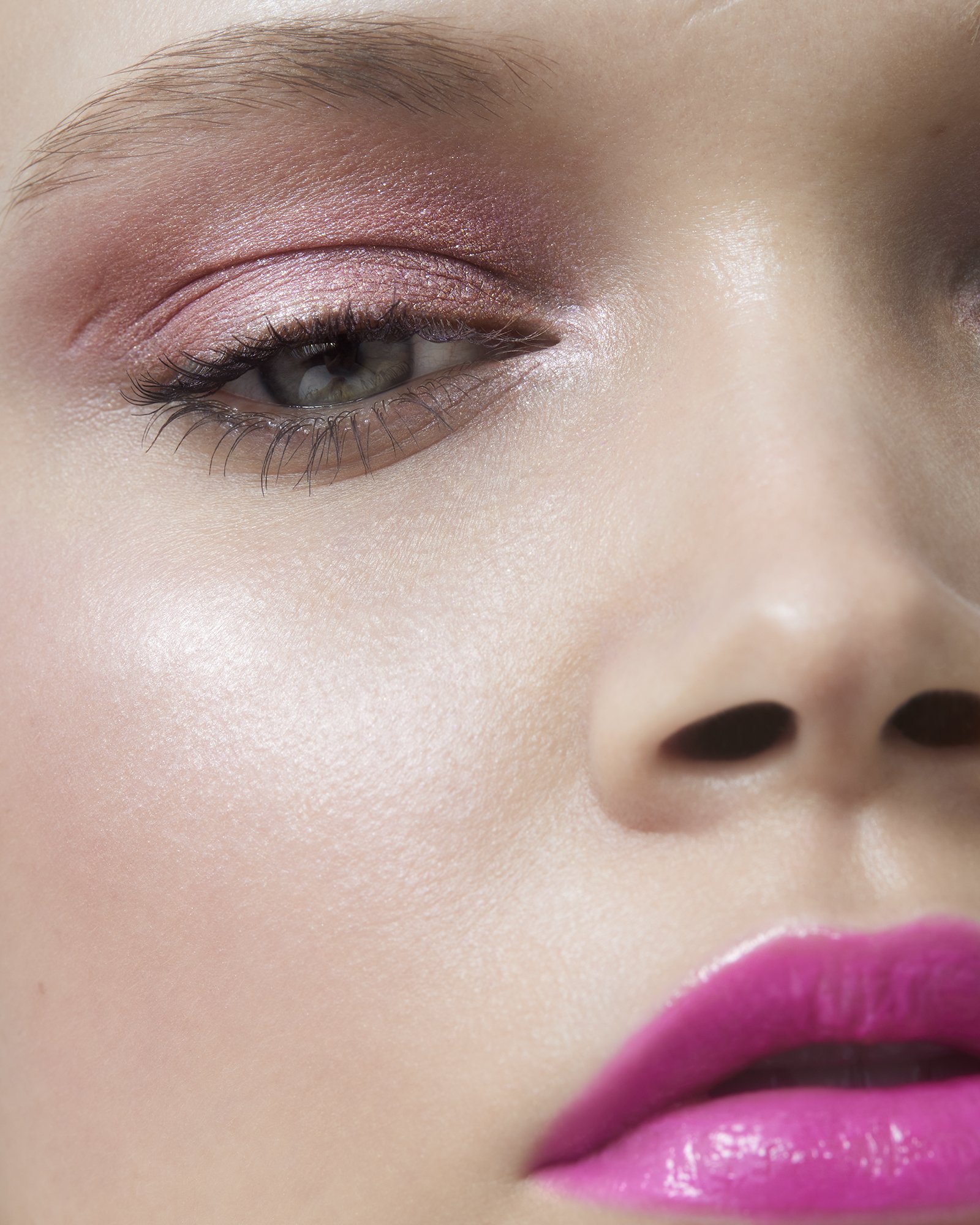 Close-up portrait of a woman wearing pink eyeshadow and glossy hot pink lipstick by director Bri Johnson.