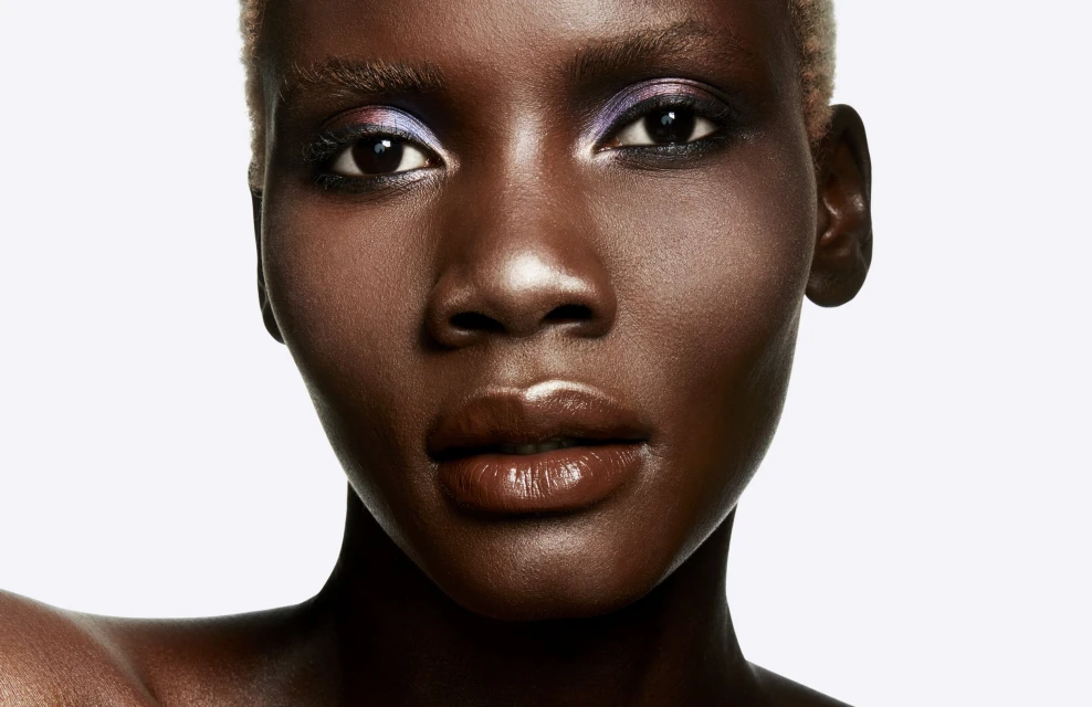 Close-up portrait of a woman with short hair and neutral makeup against a bright white background in a photo studio setting.