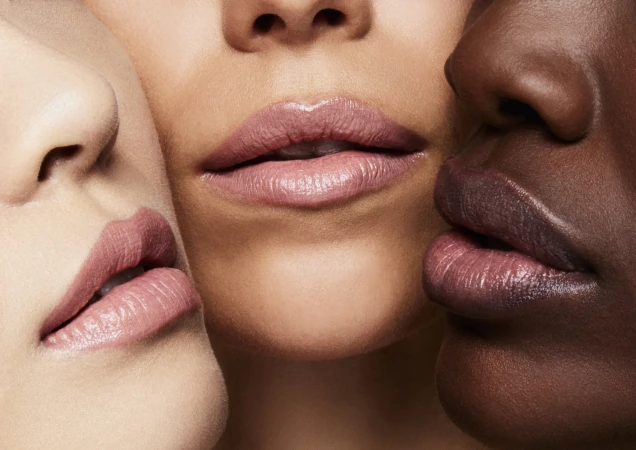 Close-up portrait featuring the lower faces and lips of three models with diverse skin tones wearing neutral lipstick.
