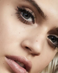 Extreme close-up macro beauty portrait of a woman showing detailed eyelashes and natural skin texture