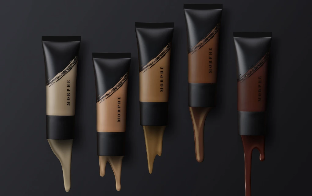 Cosmetic tubes of foundation in various shades with viscous product dripping, against a black background, beauty and cosmetics concept.