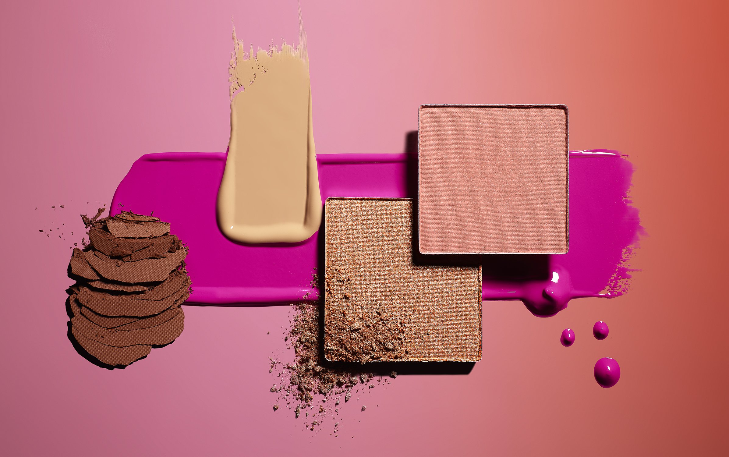 Cosmetics still life showcasing eye shadow palettes, foundation, and lip gloss against a gradient background ranging from pink to orange.