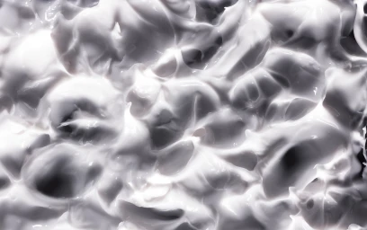 Close-up macro shot of smooth white cosmetic cream with soft peaks and rich swirls captured by Keate.