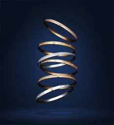 A vertical stack of six gold and silver diamond-set bangles suspended against a dark blue background.