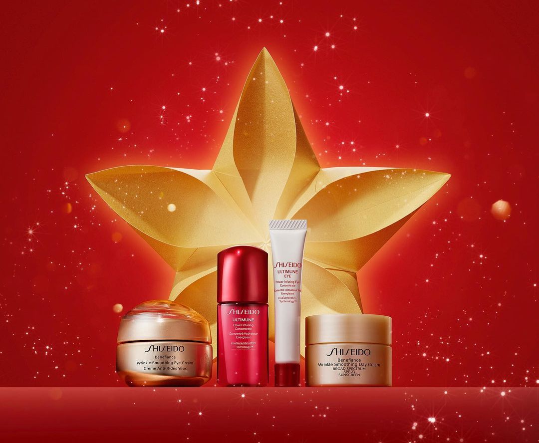 Shiseido skincare product set on a red background with a golden star. Includes cream, serum, and eye treatment in elegant containers.