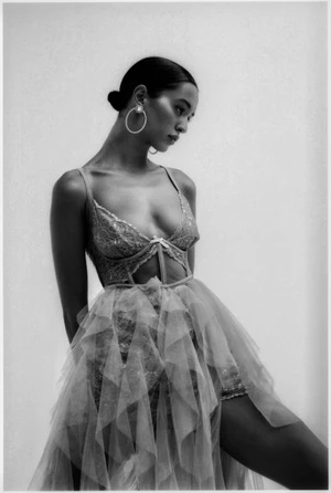 Model wearing a lace corset and tiered tulle dress with large hoop earrings in Los Angeles by photographer Bryan Rodner Carr.