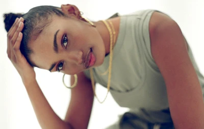 Portrait of a black woman with gold hoop earrings wearing a green tank top against a white background by Bryan Rodner Carr