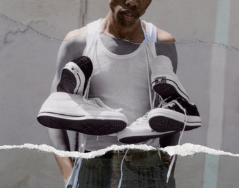 Two pairs of Converse sneakers are held by an adult male in a white tank top in front of a textured grey background, fashion photography.