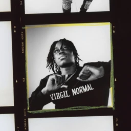 Black man wearing a black long-sleeve sweatshirt with white text posing in a medium-format film strip frame