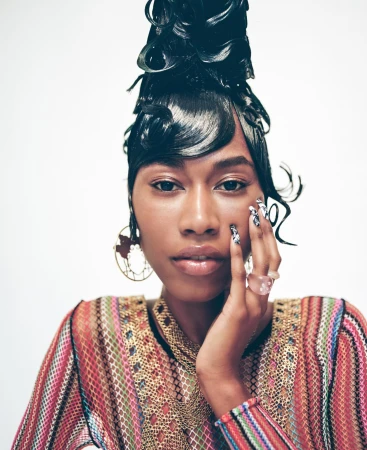 Portrait of a Black woman with sculpted wet hair, patterned knit top, and elaborate fingernails by Maiwenn Raoult