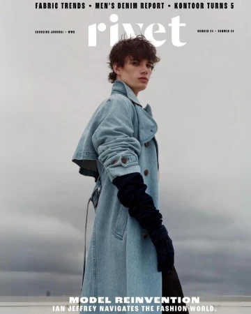Magazine cover featuring a young adult male model in a denim trench coat and gloves against a cloudy sky, promoting Rivet fashion magazine.
