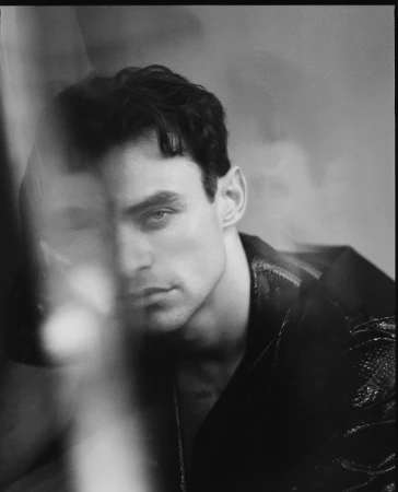 Monochrome portrait of a man with dark wavy hair and intense expression captured through multiple exposures by Matthew Priestley
