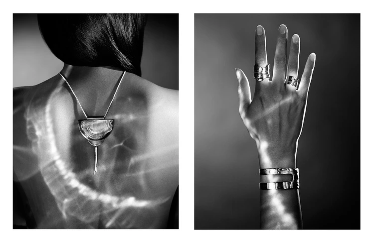 Woman's back with silver necklace and close-up of hand wearing rings and bracelet. Black and white studio jewelry fashion product shot.