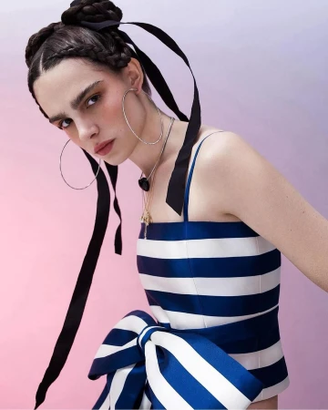 Woman in blue and white striped top with oversized bow and braided hair with black ribbons by Nadya Wasylko