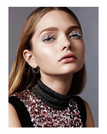 Close-up portrait of a woman with heavily sequined eyelids and a black sequined top by photographer Nadya Wasylko