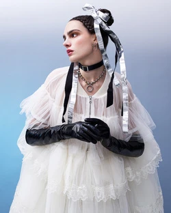 Model in layered sheer white ruffled dress with black leather gloves and silver hair ribbons by photographer Nadya Wasylko.