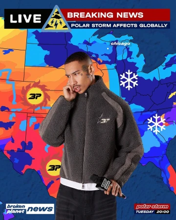 Man in grey jacket speaks on phone against weather map backdrop in studio shot. Polar storm breaking news flashes on screen.