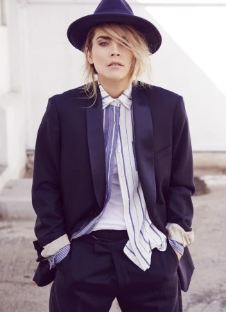 Portrait of a blonde woman wearing a fedora hat, striped button-down shirt, and a dark blazer by James Dimmock in Los Angeles.