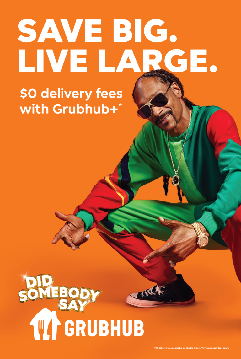 Snoop Dogg in an advertisement for Grubhub, squatting and pointing towards the Grubhub logo on an orange background, promoting food delivery.