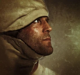 Close-up profile portrait of a man wearing a hooded garment against a textured olive background.