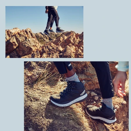 Hoka hiking boots worn by a person hiking on a rocky mountain terrain under a clear blue sky, showcasing outdoor apparel and footwear.