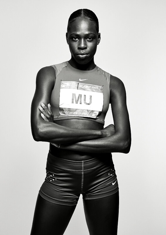 Portrait of female athlete Athing Mu in sportswear with arms crossed against a light background in a studio, black and white.