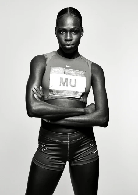 Portrait of female athlete Athing Mu in sportswear with arms crossed against a light background in a studio, black and white.