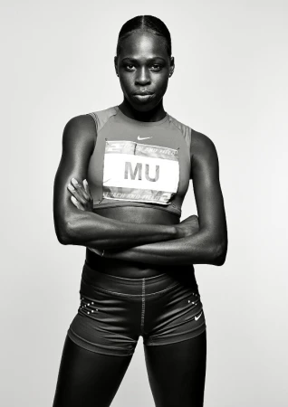 Portrait of female athlete Athing Mu in sportswear with arms crossed against a light background in a studio, black and white.