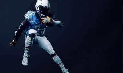 American football player in blue and white uniform running against a dark background