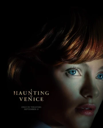 Movie poster for A Haunting in Venice featuring a close-up of a fair-skinned woman with red hair and blue eyes in a dark setting.
