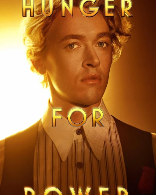 Headshot of adult male with wavy blonde hair in a striped shirt, vest and gold text overlay on a gold gradient background.