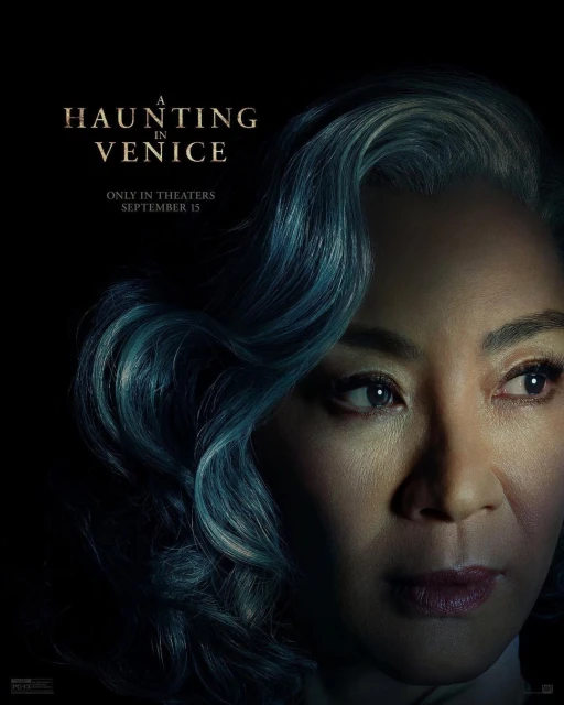 Close-up portrait of actress Michelle Yeoh with blue-grey hair, promoting 'A Haunting in Venice' movie in a dark, atmospheric setting.