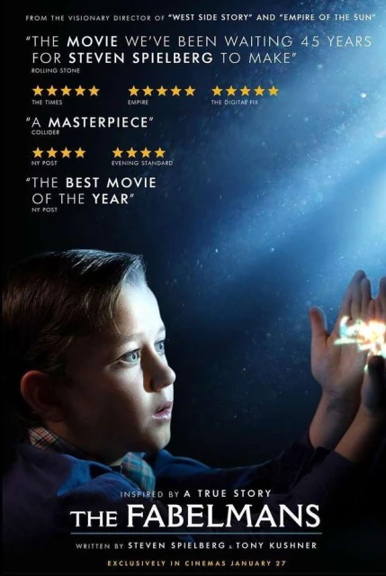 Movie poster for 'The Fabelmans' featuring a young boy gazing upwards with wonder, his hands outstretched against a blue, starlit background.