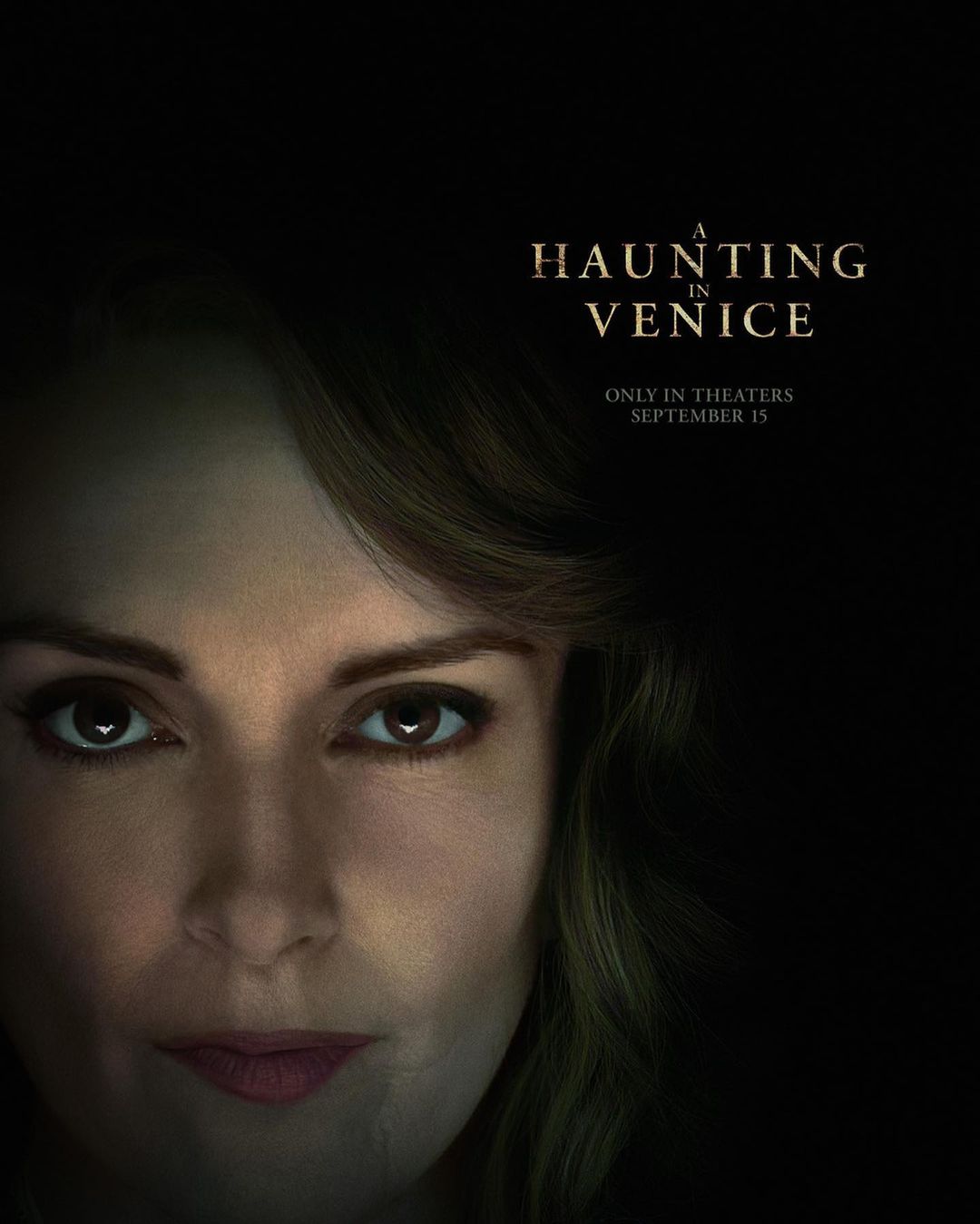 Close-up of a woman's face with dramatic lighting promoting 'A Haunting in Venice' movie, set for theaters September 15, 2023.