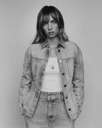 Portrait of a woman wearing a denim jacket and skirt against a seamless light background by photographer Heather Hazzan.