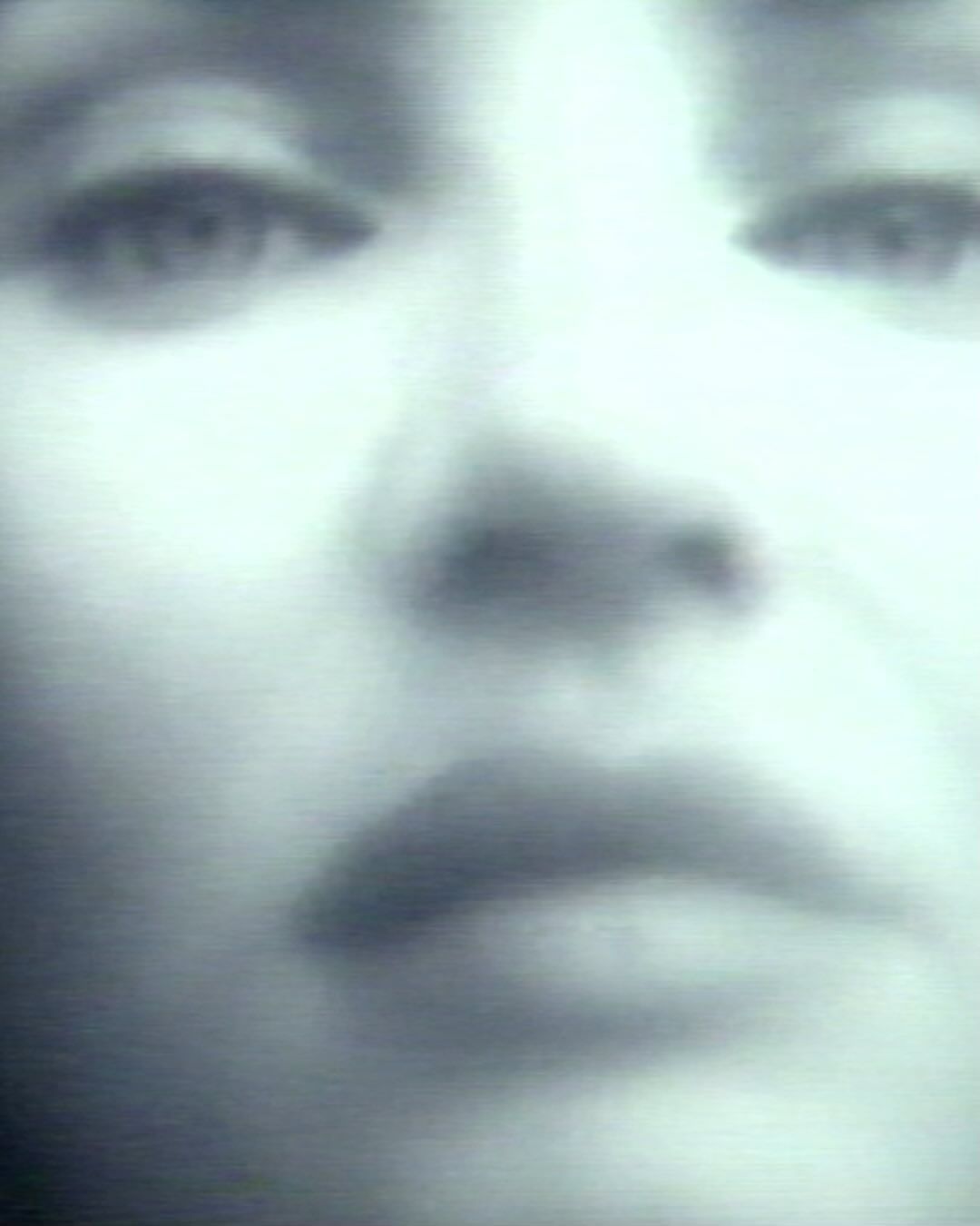 Close-up portrait of an adult female with diffused light, showcasing her face, eyes, nose, and lips in an intimate view.