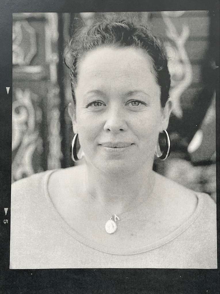 Black and white portrait of a woman wearing hoop earrings and a pendant necklace by photographer Perry Ogden