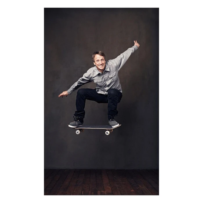 Tony Hawk mid-air on a skateboard in a studio portrait by photographer Sam Jones